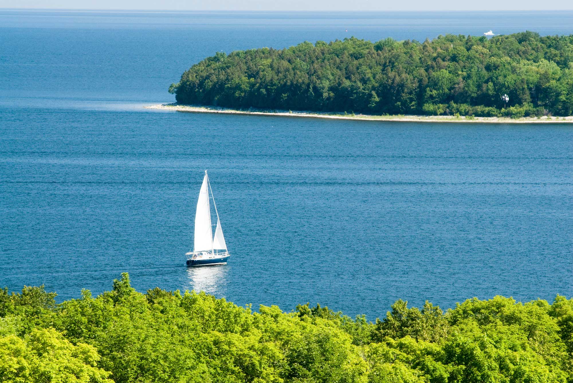 lone sailboat on a sunny day representing wealth