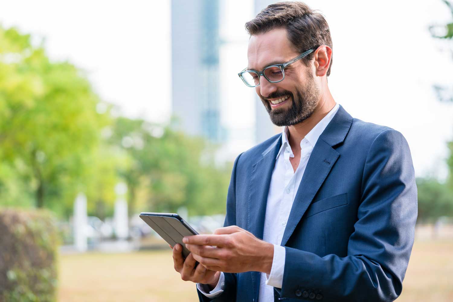 Close-up of happy businessman looking at digital tablet