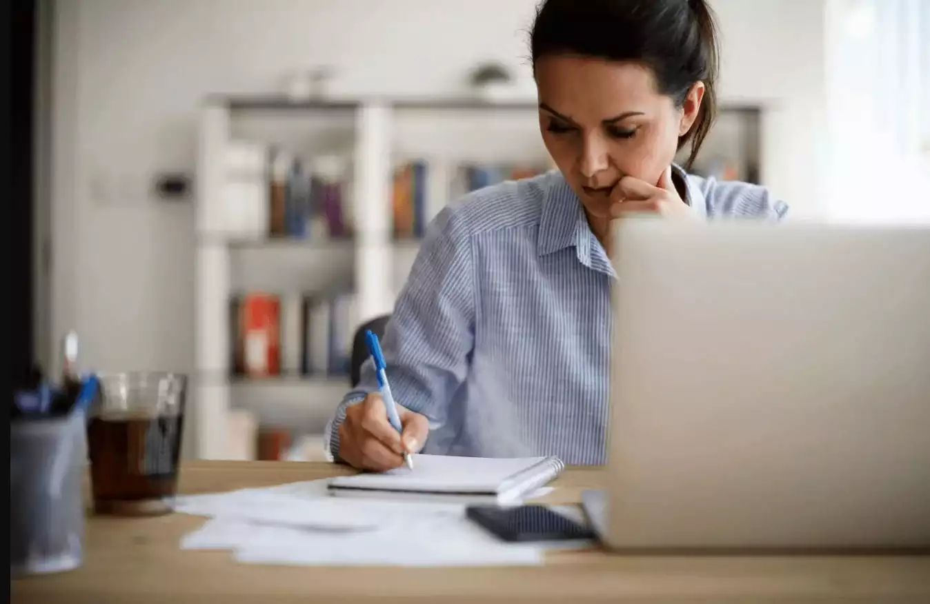 Woman writing down on her notebook