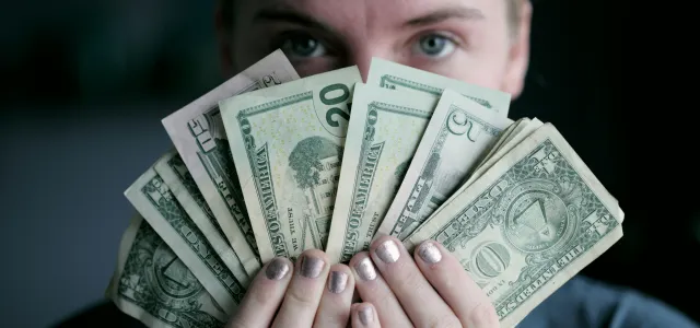 person holding fan of U.S. dollars banknote by Alexander Grey courtesy of Unsplash.